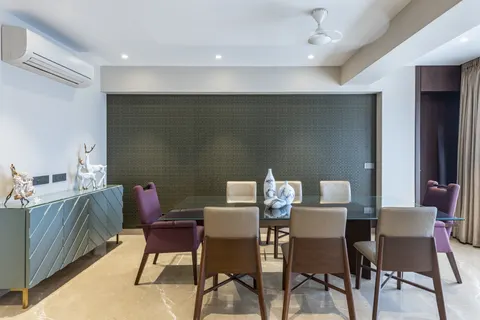 Dining room with a chevron walnut sideboard, glass-topped table, and carefully specified objects by Porcelain Sheer.